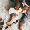 baby on rug playing with wood dog push toy